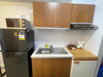 a small kitchen with a sink and a refrigerator at Staycation near SLMEC, US Embassy and Supreme Court in Manila