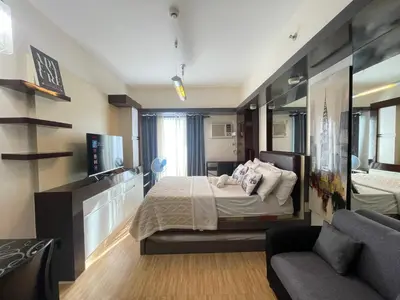a bedroom with a bed and a couch at Staycation near SLMEC, US Embassy and Supreme Court in Manila