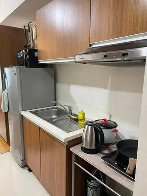 a small kitchen with a sink and a refrigerator at Condo in Ermita near UP-PGH, St Lukes & US Embassy in Manila