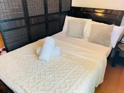 a large white bed with a stuffed animal on it at Condo in Ermita near UP-PGH, St Lukes & US Embassy in Manila