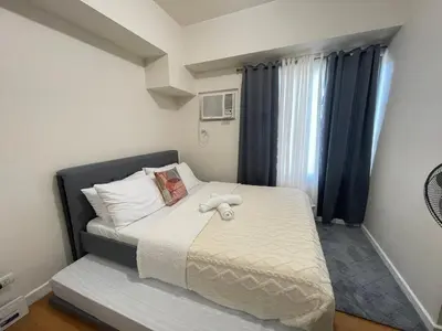 a bedroom with a bed with a stuffed animal on it at Condo in Ermita near UP-PGH, St Lukes & US Embassy in Manila