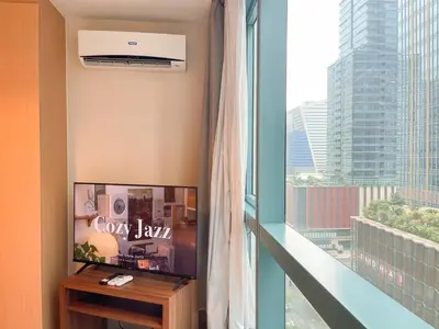 a room with a tv and a large window at Cozy Stay In Bgc Near Uptown Mall #oursw11d1 in Manila