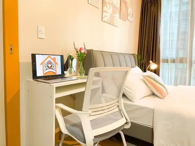 a bedroom with a desk and a bed with a laptop at Top BGC Condo Across Grand Hyatt Hotel #oursw12k in Manila