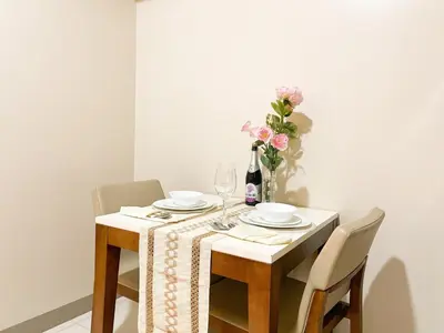 a dining room table with a vase of flowers at Top BGC Condo Across Grand Hyatt Hotel #oursw12k in Manila