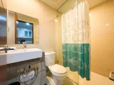 a bathroom with a toilet and a sink and a mirror at Upscale Bgc Experience 1br Condo #oursw17c2 in Manila