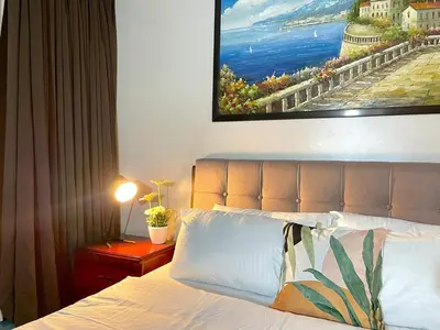 a bedroom with a bed and a painting on the wall at Luxury Bgc Condo At Uptown Area #oursw21e in Manila