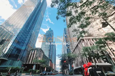 a city street with tall skyscrapers in a city at Bgc Staycation Across Uptown Mall #oursw29f in Manila