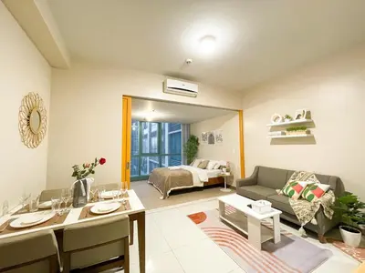 a living room with a couch and a table at Bgc Staycation Across Uptown Mall #oursw29f in Manila