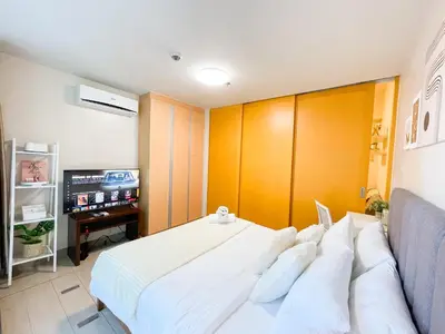 a bedroom with a white bed and a tv at Luxury BGC Condo, Steps to Uptown Mall #oursw31i in Manila