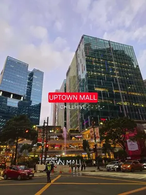 a tall building with a sign on it in a city at Luxury BGC Condo, Steps to Uptown Mall #oursw31i in Manila