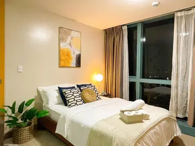 a bedroom with a bed with pillows and a window at Bgc Condo At Uptown Mall, Grand Hyatt #oursw34b2 in Manila