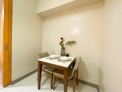 a table with two chairs and a vase with a flower on it at Bgc Condo At Uptown Mall, Grand Hyatt #oursw34b2 in Manila