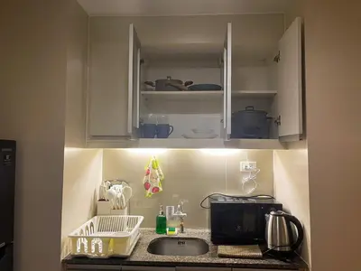 a kitchen with a sink and a microwave at Bgc Condo At Uptown Mall, Grand Hyatt #oursw34b2 in Manila