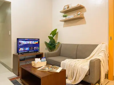 a living room with a couch and a tv at Bgc 1br Condo Across Uptown Mall, Hyatt #oursw7b2 in Manila