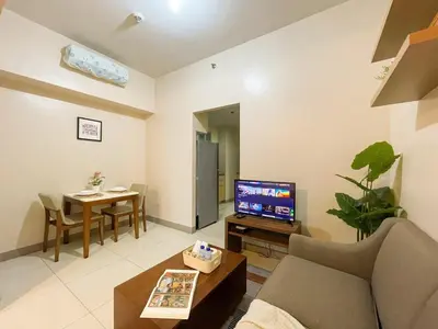 a living room with a couch and a tv and a table at Bgc 1br Condo Across Uptown Mall, Hyatt #oursw7b2 in Manila