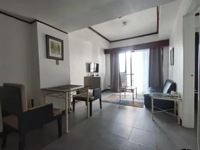a living room with a desk and a living room with a couch at Room accommodation in Manila