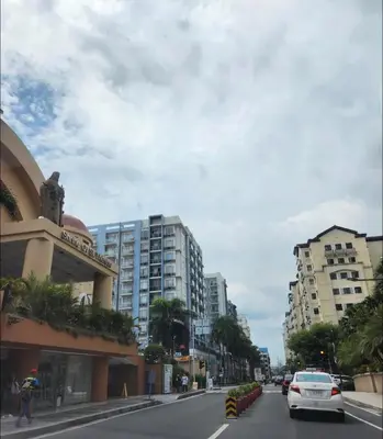 a car driving down a city street with buildings at Runway Walk Studio - Near NAIA Terminal3 in Manila