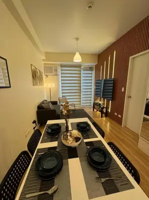 a dining room with a table and chairs and a room with at K&K The Modern Crib at Holland Park Condo Southwoods City in Biñan