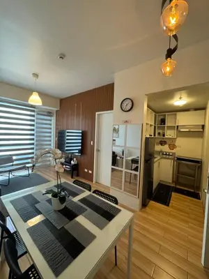 a living room with a table and a kitchen at K&K The Modern Crib at Holland Park Condo Southwoods City in Biñan