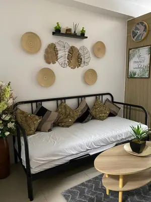 a couch with pillows on it in a living room at D'Shore to Relax Shore Residences MOA PASAY in Manila