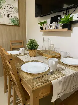 a wooden table with plates on top of it at D'Shore to Relax Shore Residences MOA PASAY in Manila