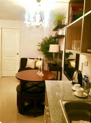 a kitchen with a table and a living room at Gorgeous 2BR Condo unit with free WiFi in Imus