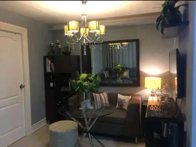 a living room with a couch and a glass table at Gorgeous 2BR Condo unit with free WiFi in Imus