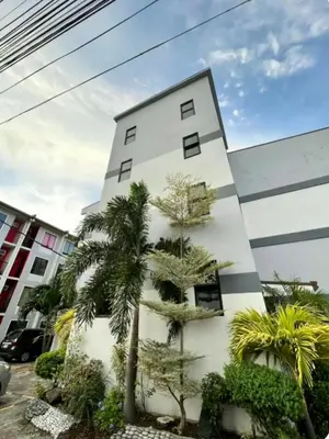 a white building with trees in front of it at Gorgeous 2BR Condo unit with free WiFi in Imus