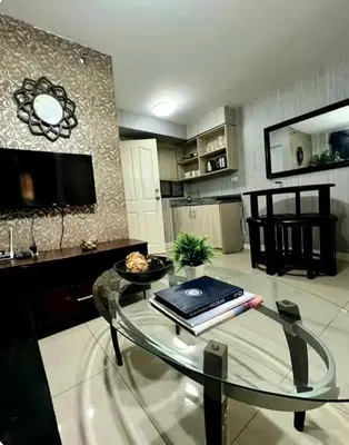 a living room with a glass table and a tv at Gorgeous 2BR Condo unit with free WiFi in Imus