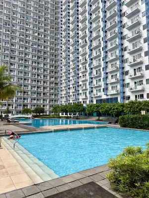 a large swimming pool in front of tall buildings at Serene Suite In Jazz Residences in Manila