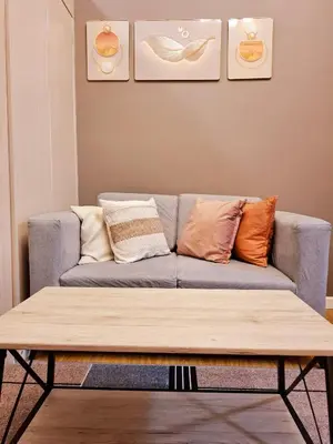 a living room with a couch with pillows on it at Serene Suite In Jazz Residences in Manila