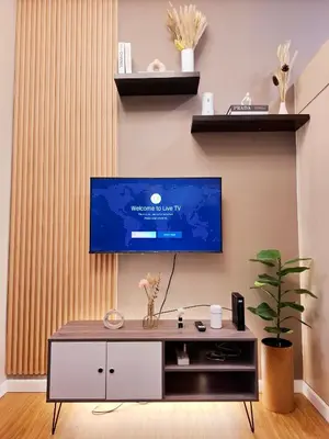 a living room with a tv on a wall at Serene Suite In Jazz Residences in Manila