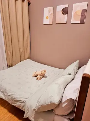 a stuffed animal is sitting on a bed at Serene Suite In Jazz Residences in Manila