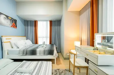 a small bedroom with a bed and a desk at BGC 2BR Uptown Parksuites with balcony and bathtub in Manila