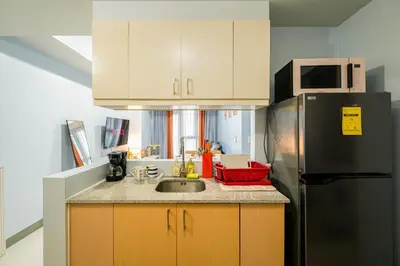a kitchen with a sink and a refrigerator at BGC 2BR Uptown Parksuites with balcony and bathtub in Manila
