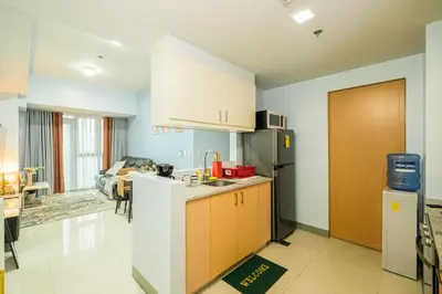 a kitchen with a sink and a refrigerator at BGC 2BR Uptown Parksuites with balcony and bathtub in Manila