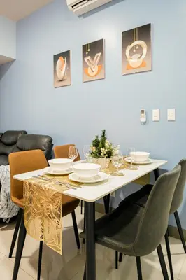 a dining room with a white table and chairs at BGC 2BR Uptown Parksuites with balcony and bathtub in Manila