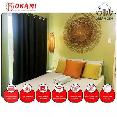 a bedroom with a bed with red and yellow pillows at Urban Zen in Calamba