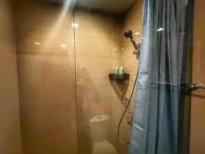 a bathroom with a shower with a glass door at EG Private House -BGC UPTOWN in Manila