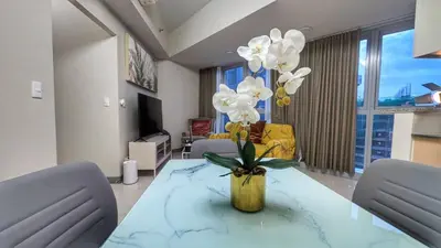 a living room with a table with white flowers on it at EG Private House -BGC UPTOWN in Manila