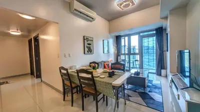 a dining room and living room with a table and chairs at EG Private House -BGC UPTOWN in Manila