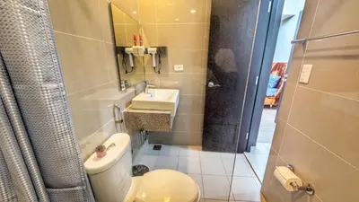 a bathroom with a toilet and a sink and a shower at EG Private House -BGC UPTOWN in Manila