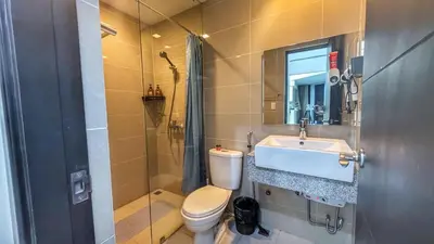 a bathroom with a toilet and a sink and a shower at EG Private House -BGC UPTOWN in Manila
