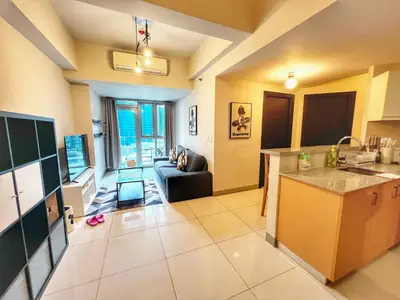 a kitchen and a living room with a couch and a table at EG Private House -BGC UPTOWN in Manila