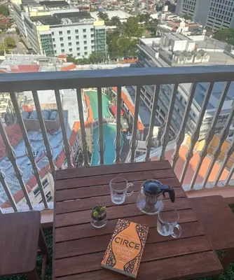 a table on a balcony with a view of a city at Amazing Sunrise Venice Grand Canal Balcony, Xbox Series X console with Game Pass Ultimate, FREE coffee, Pool, Gym & Sauna, 5 mins to BGC in Manila