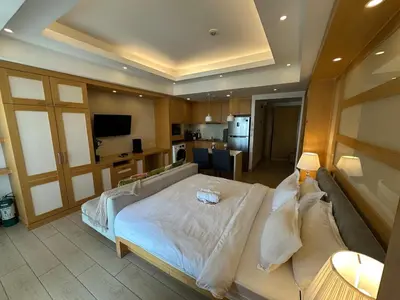 a bedroom with a large bed and a kitchen at Amazing Sunrise Venice Grand Canal Balcony, Xbox Series X console with Game Pass Ultimate, FREE coffee, Pool, Gym & Sauna, 5 mins to BGC in Manila
