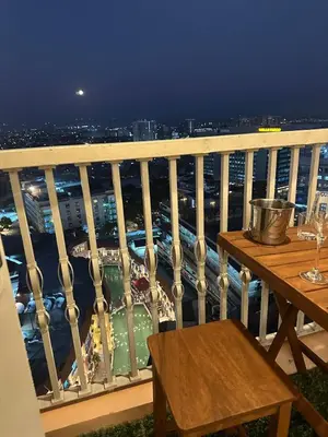 a balcony with a table and a view of a city at Amazing Sunrise Venice Grand Canal Balcony, Xbox Series X console with Game Pass Ultimate, FREE coffee, Pool, Gym & Sauna, 5 mins to BGC in Manila