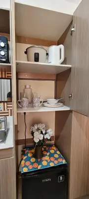 a kitchen with a shelf with pots and pans at JJMC HOMESTAY 32 With Netflix and Unli Wifi in Manila