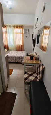 a bedroom with a bed and a table in a room at JJMC HOMESTAY 32 With Netflix and Unli Wifi in Manila