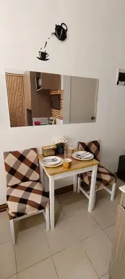 a kitchen with a table and two chairs with plates on it at JJMC HOMESTAY 32 With Netflix and Unli Wifi in Manila